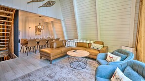 A spacious living room with a high ceiling, a dining area, and a staircase. - Wilmington Chalet w/ Hot Tub < 8 Mi to Mount Snow! (Wilmington)