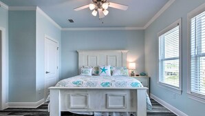 A bedroom with a white bed, a ceiling fan, and a window with blinds. - Luxe Stilted Home w/ Kayaks: Walk to Beach (Dauphin Island)