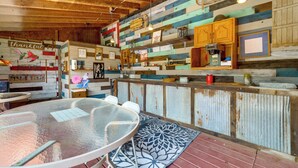 A rustic interior with a wooden ceiling, a bar area with a coffee machine, and a dining table with chairs. - Southeast Michigan Escape w/ Outdoor Fun (Adrian)