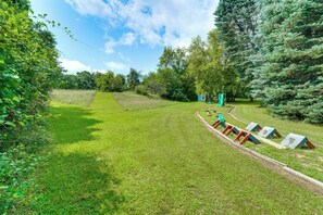 A grassy outdoor area with a playground and trees. - Southeast Michigan Escape w/ Outdoor Fun (Adrian)