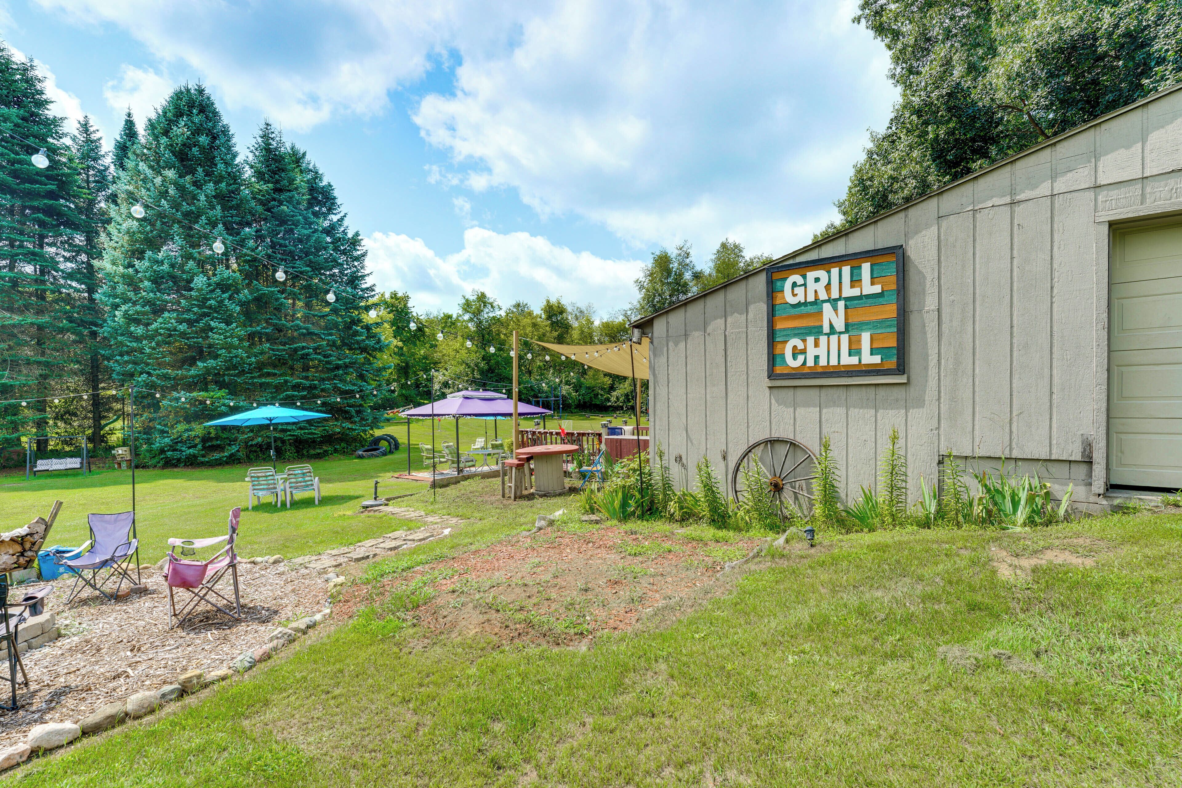 A rustic outdoor seating area with a sign reading 'GRILL N CHILL' on a building.