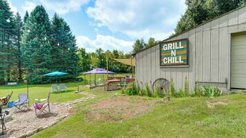 A rustic outdoor seating area with a sign reading 'GRILL N CHILL' on a building.