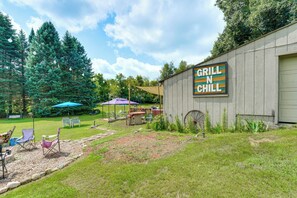 A rustic outdoor seating area with a sign reading 'GRILL N CHILL' on a building. - Southeast Michigan Escape w/ Outdoor Fun (Adrian)