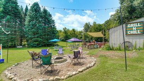 Patio trasero con fogata, asientos exteriores y un letrero que dice 'Grill N Chill'.