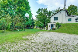 A residential area with a basketball court, a house, and surrounding greenery. - Southeast Michigan Escape w/ Outdoor Fun (Adrian)