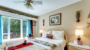 A bedroom with a bed, bedside tables, a nightstand, a ceiling fan, a window with curtains, and a view of the outdoors. - Southeast Michigan Escape w/ Outdoor Fun (Adrian)