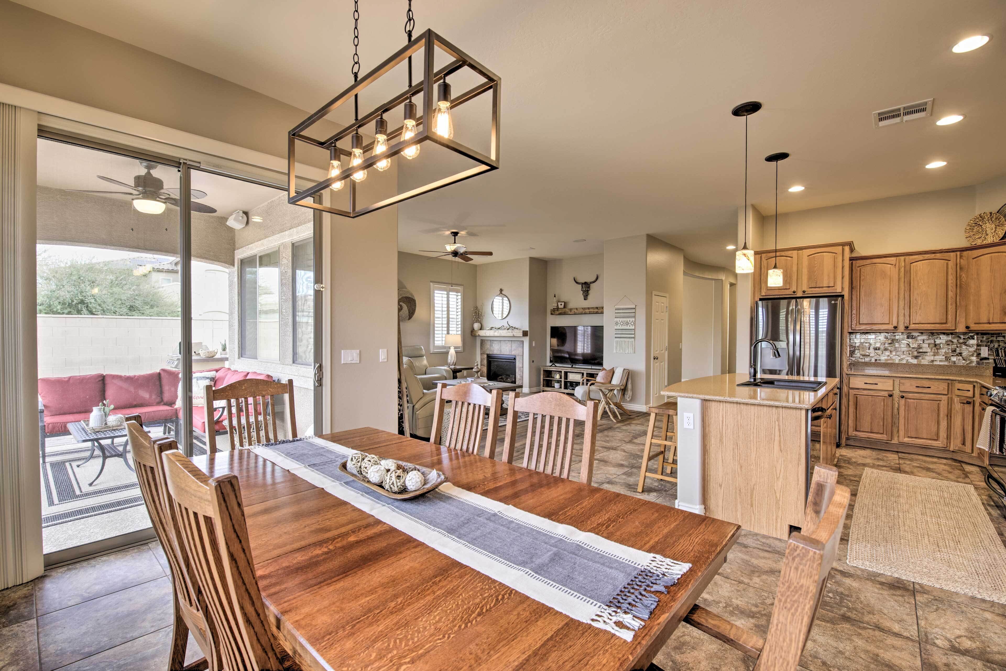 A spacious dining area with a wooden table, chairs, and a chandelier.