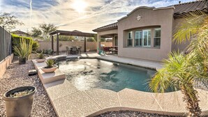 A backyard with a swimming pool, patio furniture, and a covered seating area. - Goodyear Home w/ Pool: Near Golf & Ballpark! (Goodyear)