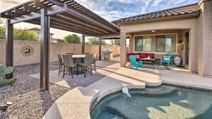A covered patio with a pool, outdoor seating, and a pergola. - Goodyear Home w/ Pool: Near Golf & Ballpark! (Goodyear)