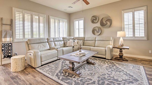 A spacious living room with a beige sectional sofa, a wooden coffee table, and a patterned rug. - Goodyear Home w/ Pool: Near Golf & Ballpark! (Goodyear)