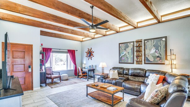 A spacious living room with a leather sofa, wooden coffee table, and a ceiling fan. - 'bear Canyon Casa' - Tucson Home Base w/ Mtn Views (Tucson)