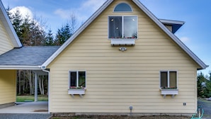 Ein zweigeschossiges Haus mit Satteldach, Dachfenstern und einer Veranda.