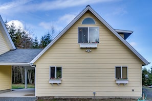 A two-story house with a gabled roof, dormer windows, and a covered porch.