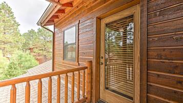 Eine Holzhütte mit einer Holzdar Terrasse und einer Glastür.