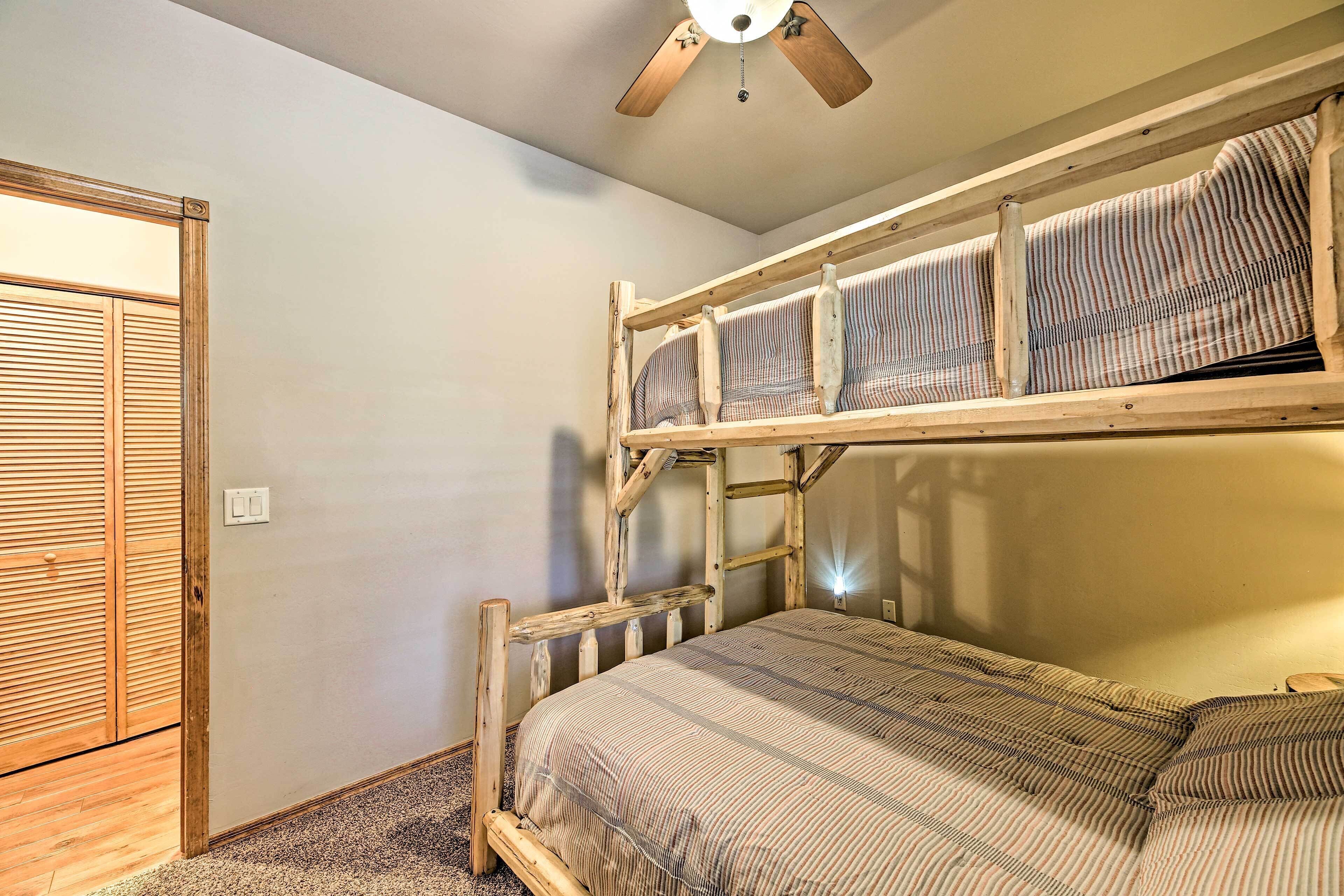 A bunk bed with a wooden ladder and a striped bedspread.