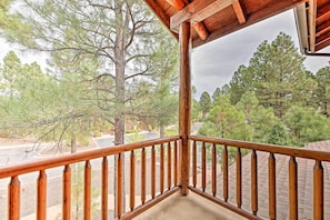 A wooden balcony railing overlooking a road and trees. - < 1 Mi to Torreon Golf Club: Show Low Condo (Show Low)