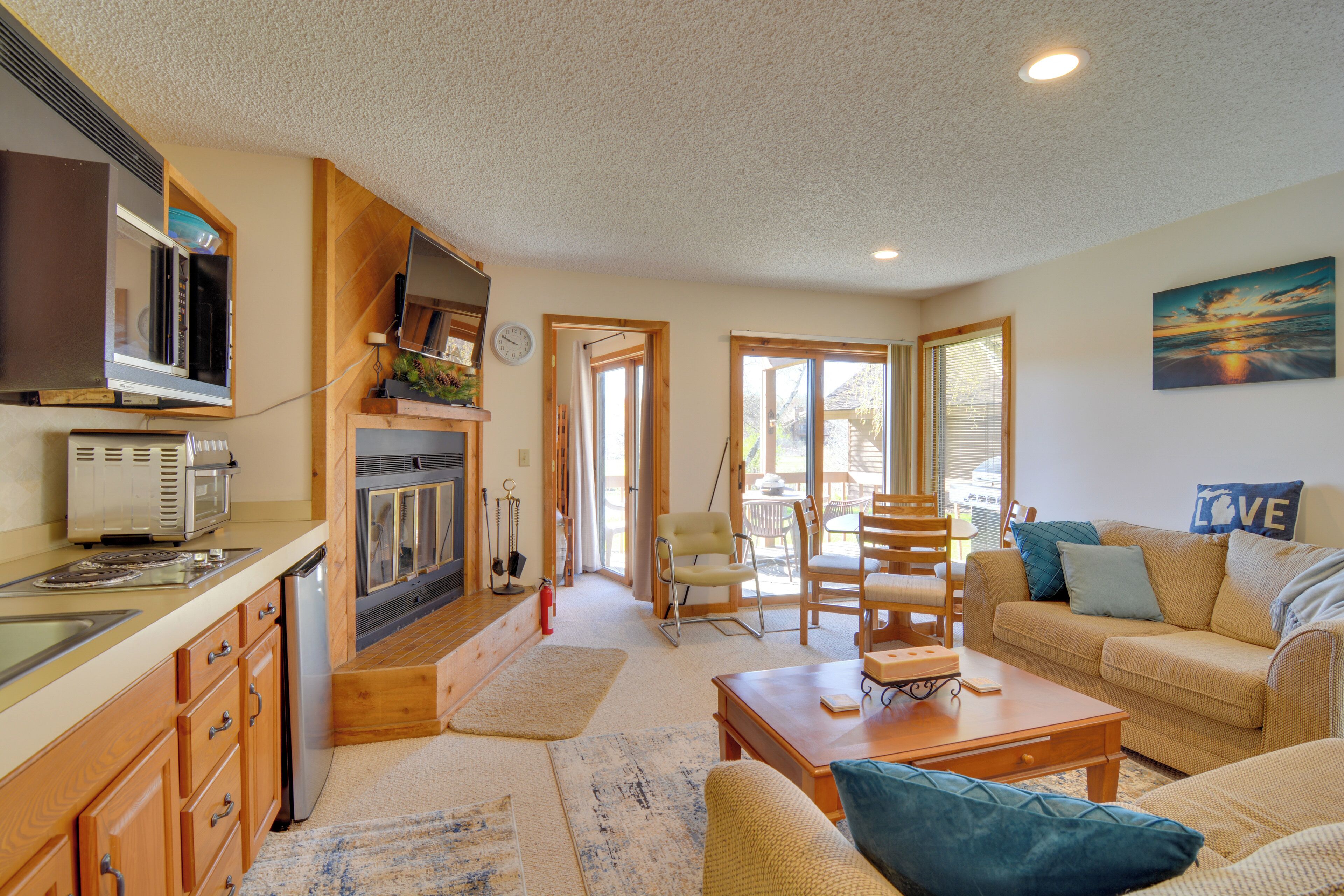 A cozy living room with a sofa, coffee table, and a dining area with chairs.