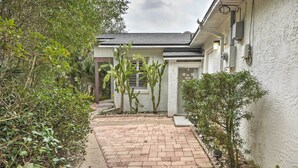 A pathway leading to a house with a white exterior, surrounded by greenery and a brick patio. - Pet-friendly Flagler Beach Home w/ Yard Near Beach (Flagler Beach)