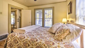 Un dormitorio con cama, ventilador de techo y ventana con persianas.