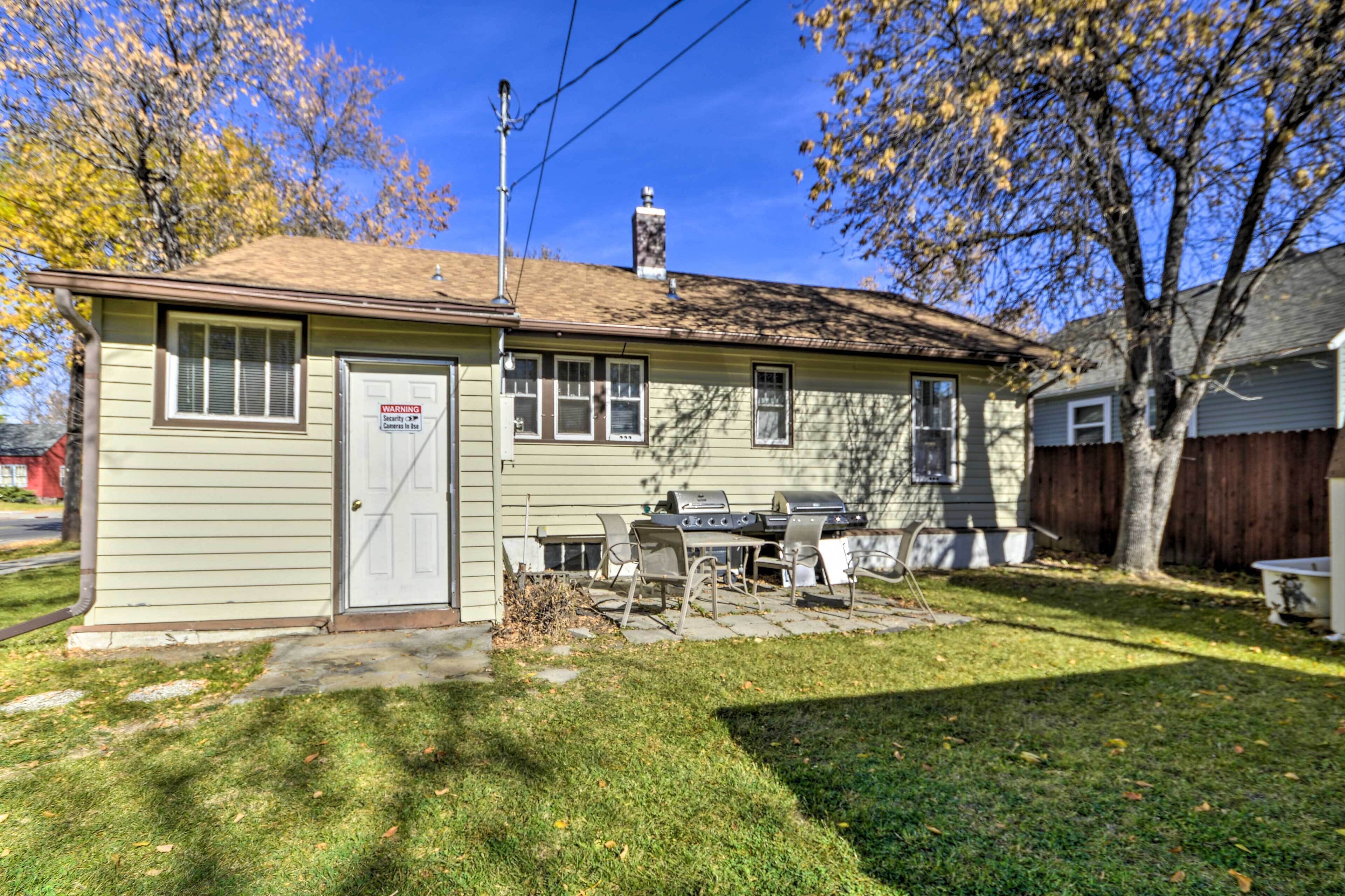 Une petite maison avec un garage, un barbecue et un panneau d’avertissement sur la porte du garage.