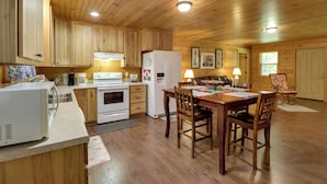 Ein Holzblockhaus mit Küche, Essbereich und einem gemütlichen Wohnraum.