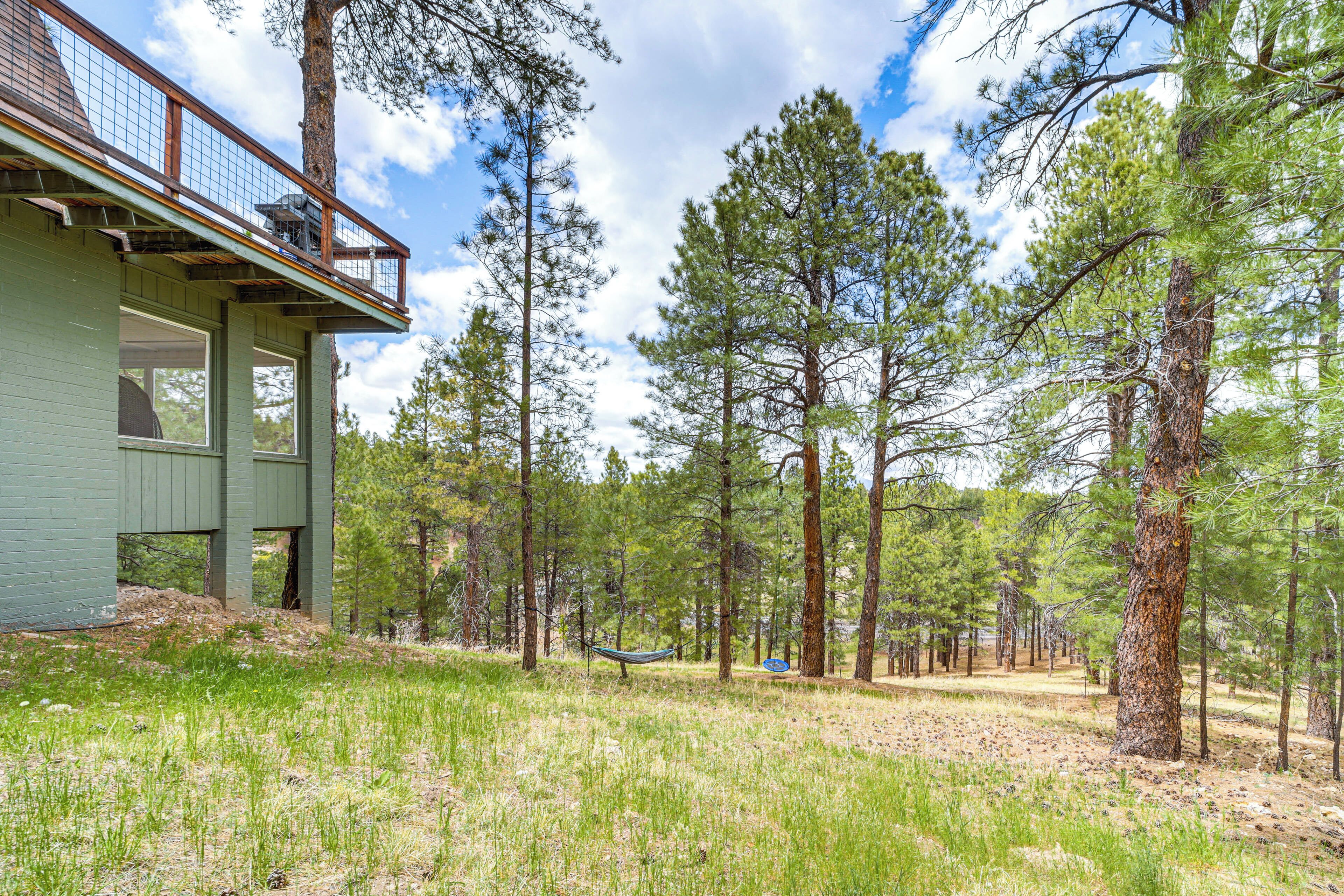 A cabin with a balcony overlooking a forested area.