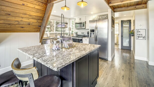 A kitchen with granite countertops, stainless steel appliances, and wooden ceiling beams. - Flagstaff A-frame Cabin w/ Deck & Lovely Views! (Flagstaff)