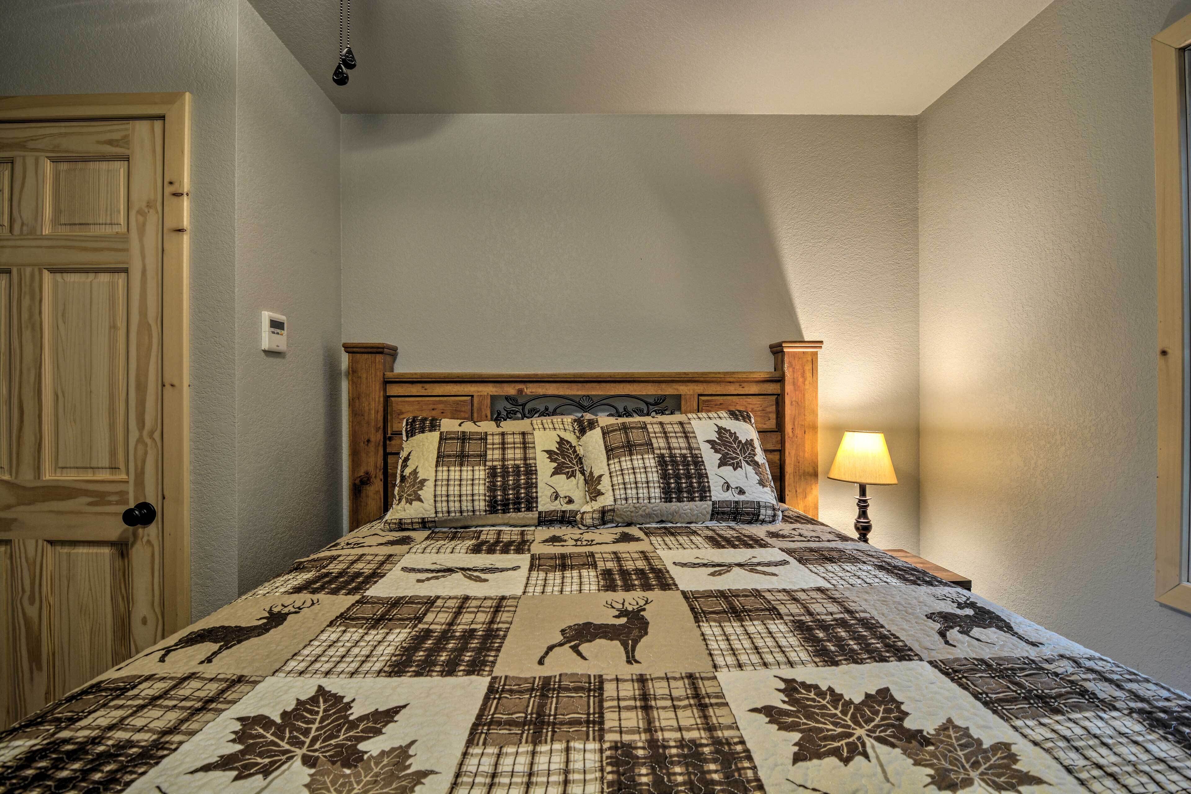 Une chambre à coucher avec une tête de lit en bois, une courtepointe à motifs animaliers, une lampe de chevet et une porte.