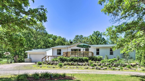 A single-story house with a covered porch, a garage, and a well-maintained lawn.
