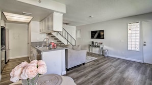 A spacious living area with a kitchen, a staircase, and a dining area. - Palm Desert Resort-style Living: Dog Friendly (Palm Desert)