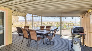 A covered outdoor patio with a table and chairs, a grill, and a view of a natural landscape. - Boat Launch + Mtn Views: Lake Havasu Cabin (Lake Havasu City)