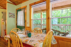 A wooden interior with a dining table set for two, surrounded by chairs. - Secluded Nantahala 'gone Hunting' Cabin w/ Hot Tub (Bryson City)