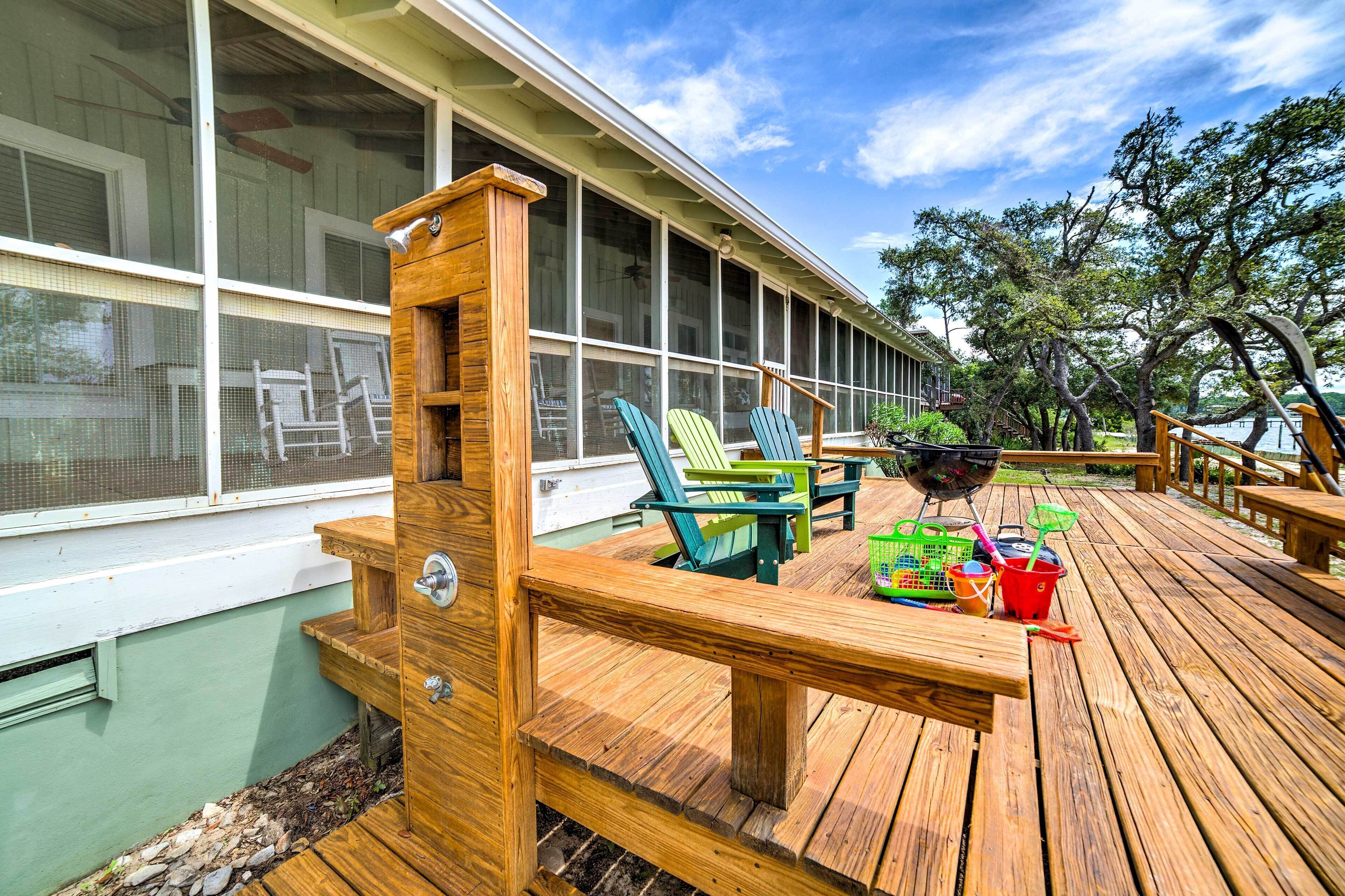 A wooden deck with outdoor seating and a grill.