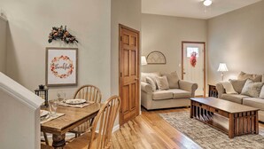 A living room with a wooden dining table, two chairs, a sofa, and a coffee table. - Unique Ovid Apt w/ Grill on Cayuga Wine Trail! (Ovid)