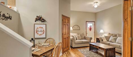 Un comedor con mesa y sillas de madera, un sofá y una mesa baja en la sala.