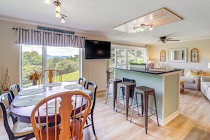 A spacious kitchen with a dining area, large windows, and a view of the outdoors.