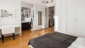 A modern bedroom with a bed, a desk, and a wardrobe. - Basilica View Apartment With Balcony (Budapest)