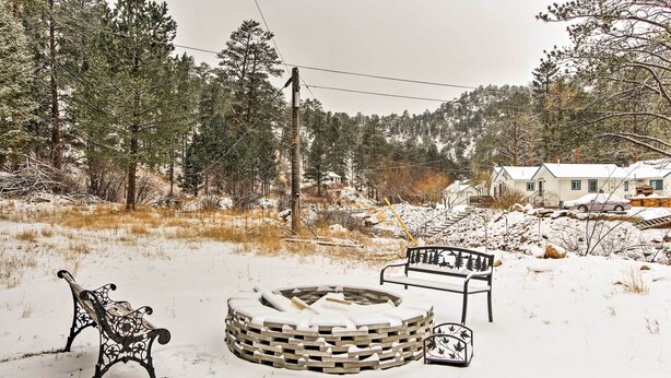 A snow-covered outdoor area with a circular fire pit, two benches, and a bench with a tree design. - Drake Home on Big Thompson River - 3 Mi. to Estes! (Drake)