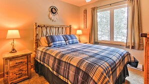 A bedroom with a large bed, two bedside tables, a ceiling fan, and a window with curtains. - Drake Home on Big Thompson River - 3 Mi. to Estes! (Drake)