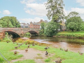 A river with ducks, a bridge, and buildings in the background. - Bolton Cottage (Appleby-in-Westmorland)