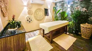A spa room with a reception desk, a massage table, and a wall with decorative woven panels and a tropical wallpaper backdrop. - Tranquil Haven in North Al Ahyaa, Hurghada (Hurghada)
