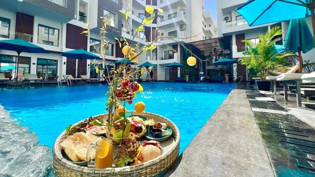 A swimming pool with lounge chairs and umbrellas, surrounded by modern buildings. - Tranquil Haven in North Al Ahyaa, Hurghada (Hurghada)