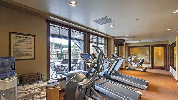 A fitness center with treadmills, a water cooler, and a sign detailing fitness rules. - Ski-in/ski-out Breckenridge Resort Condo at Peak 7 (Breckenridge)