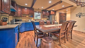 A spacious kitchen with wooden cabinets, a large island, and a dining area with a wooden table and chairs.