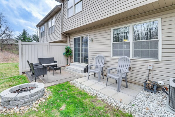 A house with a patio area featuring a fire pit, outdoor furniture, and a stone fire pit.
