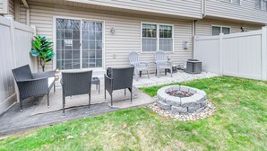 Un jardin avec un espace patio, un foyer extérieur et du mobilier de jardin.