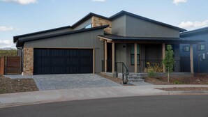 A modern two-story house with a stone facade, a large garage, and a covered porch. - Modern Flagstaff Escape w/ Grill, 3 Mi to Downtown (Flagstaff)