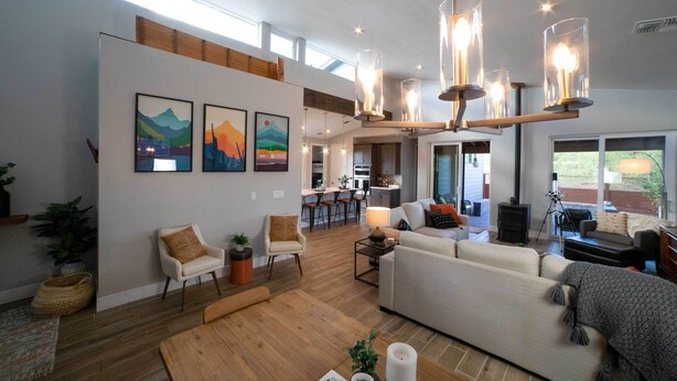 A spacious living area with a large sofa, a dining table, and a kitchen in the background. - Modern Flagstaff Escape w/ Grill, 3 Mi to Downtown (Flagstaff)