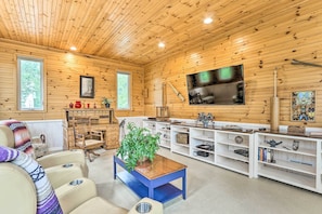 Una sala de estar acogedora con paredes de madera, una mesita de centro azul y un televisor.