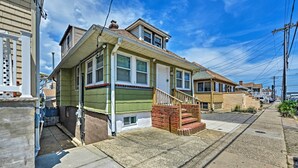 A two-story house with a front porch, a small front yard, and a driveway. - Inviting Seaside Heights Apt < 1 Mi to Beach! (Seaside Heights)